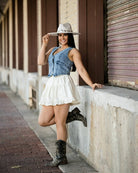 Model wearing sleeveless button down denim vest