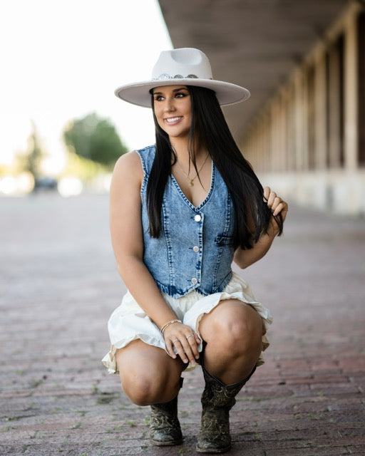 Model wearing sleeveless button down denim vest