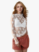 Model wearing white sheer lace top with long sleeves and mock neck, great for any season and layering
