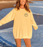 girl wearing yellow comfort colors sweatshirt saying here for the good times and a smiley face