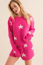 Model wearing a cozy pink lounge set with a star print design. The set includes a relaxed-fit, long-sleeve top with white star accents and matching drawstring shorts, perfect for comfortable and stylish loungewear