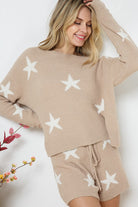 Model wearing a cozy beige lounge set with a star print design. The set includes a relaxed-fit, long-sleeve top with white star accents and matching drawstring shorts, perfect for comfortable and stylish loungewear