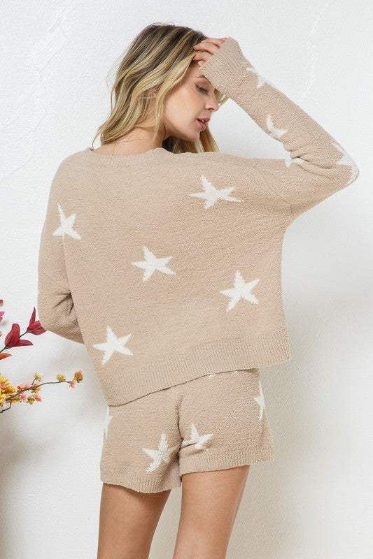 Model wearing a cozy beige lounge set with a star print design. The set includes a relaxed-fit, long-sleeve top with white star accents and matching drawstring shorts, perfect for comfortable and stylish loungewear