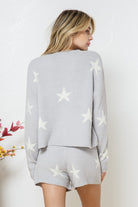 Model wearing a cozy grey lounge set with a star print design. The set includes a relaxed-fit, long-sleeve top with white star accents and matching drawstring shorts, perfect for comfortable and stylish loungewear