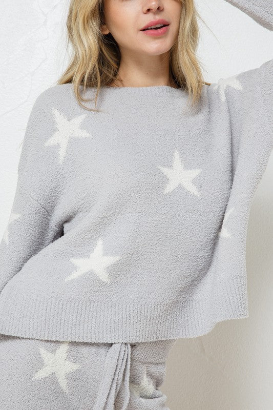 Model wearing a cozy grey lounge set with a star print design. The set includes a relaxed-fit, long-sleeve top with white star accents and matching drawstring shorts, perfect for comfortable and stylish loungewear