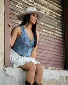 Model wearing sleeveless button down denim vest