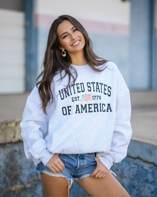 Model wearing Sunkissed Coconut pearl grey USA embroidered flag sweatshirt