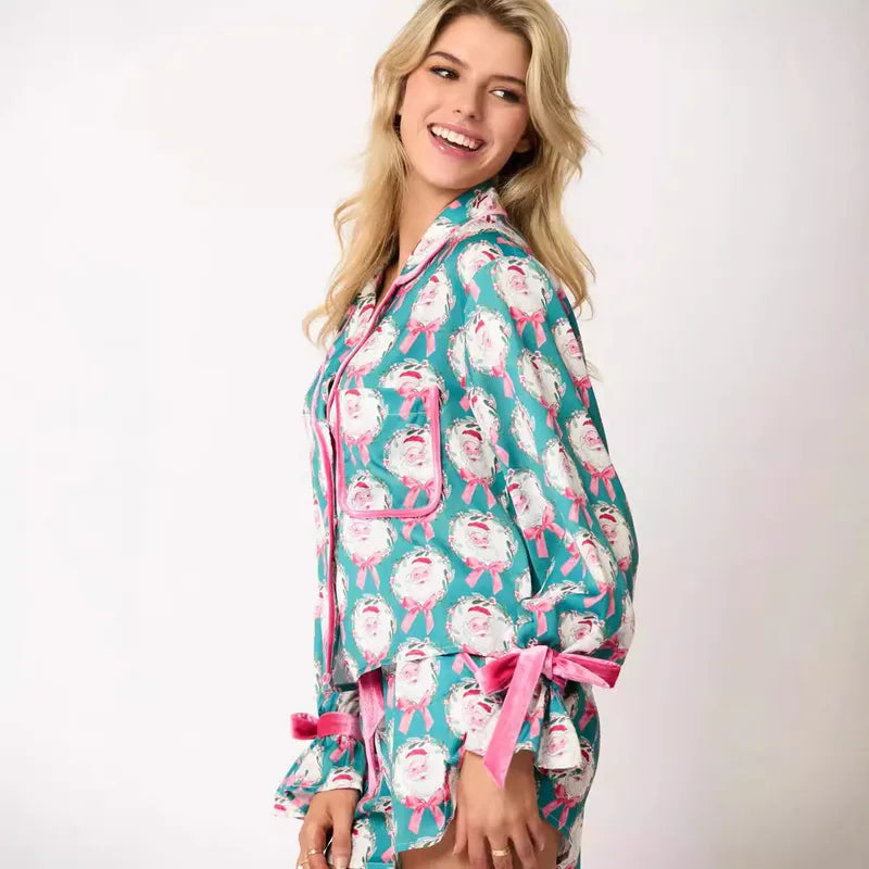 Women's teal holiday pajama set with Santa Claus wreath print, featuring a long-sleeve top and relaxed-fit shorts with festive rose piping, ruffle details velvet bow ties, perfect cozy sleepwear or holiday gift for women. Trendy, cute Christmas loungewear for stylish comfort during holiday movie nights, gift exchanges, or lounging at home.