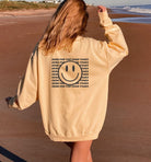 girl wearing yellow comfort colors sweatshirt saying here for the good times and a smiley face