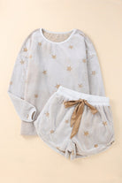 Women's cozy star-print lounge set with long-sleeve top and matching shorts, featuring soft beige fabric with gold stars and an adjustable satin ribbon tie. Perfect for stylish loungewear or sleepwear, ideal for young women looking for cute and comfortable at-home outfits or giftable sets.